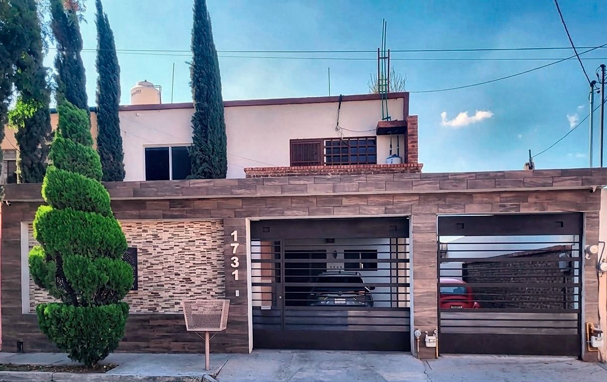 Fachada con cochera para tres autos